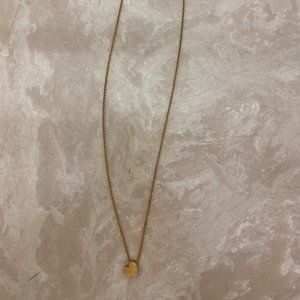 Delicate gold necklace with a heart charm and "Mama" engraved on back